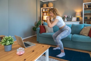Ciddi bir araba kazasından sonra iyileşen genç bir kadın, kaslarını esneten, yoga minderi üzerinde rehabilitasyon egzersizleri yapan, bina dayanıklılığı, esneklik ve kapalı alanda esneklik sağlayan bir kadın.