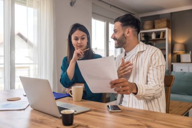 Finans ve ekonomi. Genç bir çift, küçük işletme sahipleri, yerel ofiste çalışıyorlar, sunum ve çevrimiçi koçluk için video çağrısı hazırlıyorlar. E-ticaret adamı ve kadın profesyonel mesleği