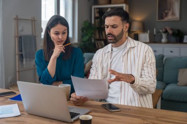 Finans ve ekonomi. Genç bir çift, küçük işletme sahipleri, yerel ofiste çalışıyorlar, sunum ve çevrimiçi koçluk için video çağrısı hazırlıyorlar. E-ticaret adamı ve kadın profesyonel mesleği