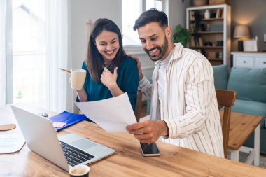 Finans ve ekonomi. Genç bir çift, küçük işletme sahipleri, yerel ofiste çalışıyorlar, sunum ve çevrimiçi koçluk için video çağrısı hazırlıyorlar. E-ticaret adamı ve kadın profesyonel mesleği