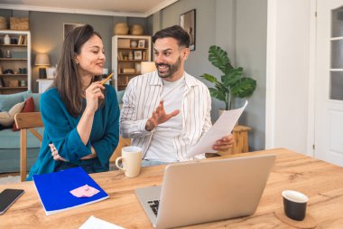 Finans ve ekonomi. Genç bir çift, küçük işletme sahipleri, yerel ofiste çalışıyorlar, sunum ve çevrimiçi koçluk için video çağrısı hazırlıyorlar. E-ticaret adamı ve kadın profesyonel mesleği