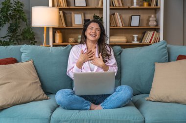 Evdeki mutlu kadın internetten randevulaşma videosu için laptop kullanıyor. Heyecanlı genç bayan, web kamerası sohbeti, sanal romantik bağlantı ve dijital ilişki deneyimi yoluyla aşk ile tanışır..