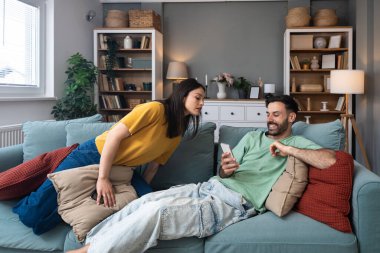 Evde akıllı telefon kullanan kıskanç bir kadınla partneri arasındaki ilişki anlaşmazlığı, iletişim sorunlarını, güven sorunlarını, duygusal gerilimi ve çiftlerde dijital dikkat dağınıklığını gösteriyor
