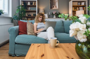 Konsantre olmuş milenyum kızı, evinde dizüstü bilgisayarla internette gezinirken tembelce hafta sonu boyunca bilgisayar sörfü yaparak internetten internet alışverişi yapmakla meşgul.