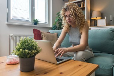 Konsantre olmuş milenyum kızı, evinde dizüstü bilgisayarla internette gezinirken tembelce hafta sonu boyunca bilgisayar sörfü yaparak internetten internet alışverişi yapmakla meşgul.