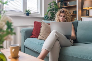 Konsantre olmuş milenyum kızı, evinde dizüstü bilgisayarla internette gezinirken tembelce hafta sonu boyunca bilgisayar sörfü yaparak internetten internet alışverişi yapmakla meşgul.