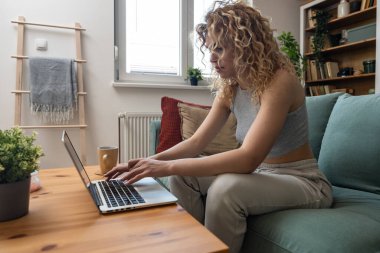 Konsantre olmuş milenyum kızı, evinde dizüstü bilgisayarla internette gezinirken tembelce hafta sonu boyunca bilgisayar sörfü yaparak internetten internet alışverişi yapmakla meşgul.