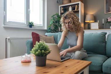 Konsantre olmuş milenyum kızı, evinde dizüstü bilgisayarla internette gezinirken tembelce hafta sonu boyunca bilgisayar sörfü yaparak internetten internet alışverişi yapmakla meşgul.