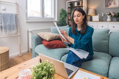 Bin yıllık bağımsız, olumlu, yakışıklı kadın ofis işi. Yetişkin akıl hocası serbest çalışan bir iş kadını blogcu dizüstü bilgisayar kamerasıyla koltukta oturuyor ve meslektaşıyla konuşuyor. Video çağrısı görüşmesi.