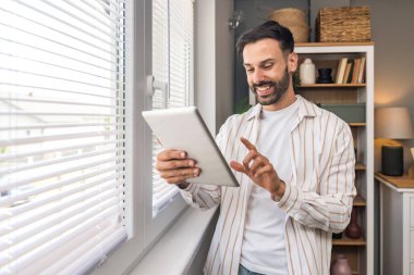 Ofisteki pencerenin yanında dijital tabletle duran genç mutlu adam psikoterapisti, hastadan iyi haberlerle dolu bir e-posta aldıktan sonra heyecanlanıyor. Pozitif çevrimiçi psikoterapi sonuç kavramı