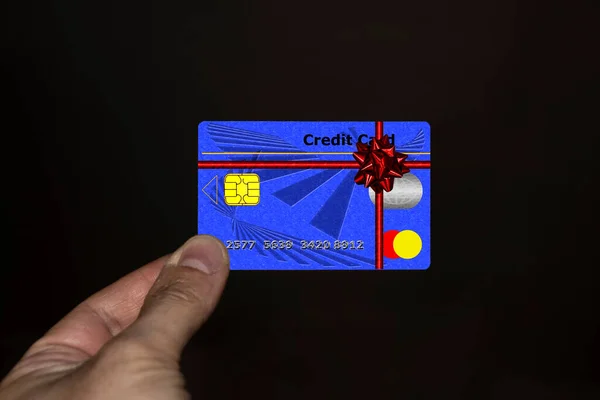 リボンとカクテル付きのクレジットカードを持っている手 — ストック写真