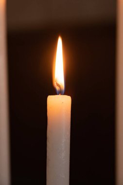 Ön planda yanan tek bir mum