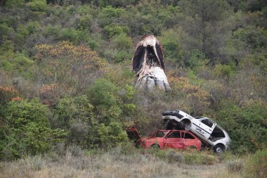 Estella, Spain - 30 Oct 2022: Parque de los Desvelados, an open air art installation with giant skulls and ruined vehicles clipart