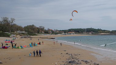 Santander, İspanya - 31 Ekim 2022: Uçurtma sörfçüleri ve yüzüleri Playa de los Peligros plajı, Santander, Cantabria
