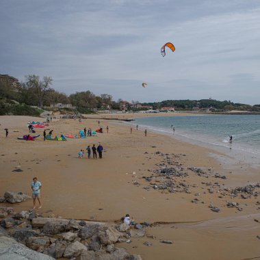 Santander, İspanya - 31 Ekim 2022: Uçurtma sörfçüleri ve yüzüleri Playa de los Peligros plajı, Santander, Cantabria