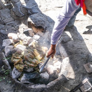 Cusco, Peru - 3 Aralık 2022: Sıcak taşlar ve toprak kullanarak geleneksel Pachamanca pişirme