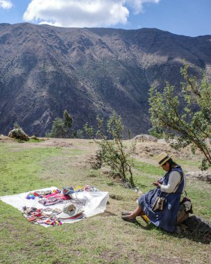 Cusco, Peru - 3 Aralık 2022: Peru And Dağları 'nda el sanatlarını örüp satan yerel bir Andean kadını