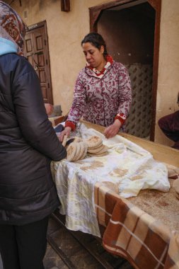Marakeş, Fas - 6 Şubat 2023: Marakeş Çarşısında taze ekmek satan bir kadın