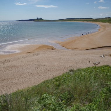 Low Newton, İngiltere - 13 Temmuz 2023: Dunstanburgh kalesi ve Northumbria kıyıları, Deniz kenarındaki Low Newton