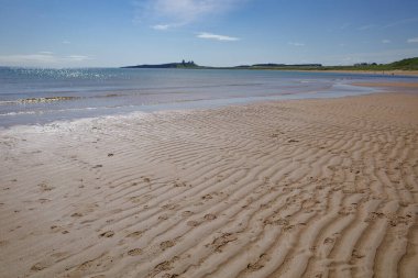 Low Newton, İngiltere - 13 Temmuz 2023: Dunstanburgh kalesi ve Northumbria kıyıları, Deniz kenarındaki Low Newton