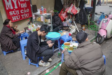 Hanoi, Vietnam - 9 Şubat 2024: Hanoi 'nin eski mahallesindeki bir lokantada yemek yiyenler