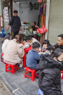Hanoi, Vietnam - 9 Şubat 2024: Hanoi 'nin eski mahallesindeki bir lokantada yemek yiyenler