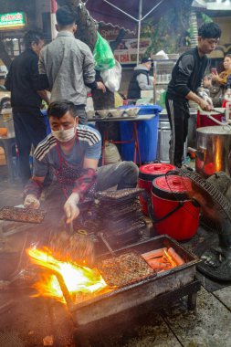 Hanoi, Vietnam - 9 Şubat 2024: Bir adam geleneksel Vietnamlı şehriye çorbası çorbası olan Bun Cha 'yı barbeküye çevirdi