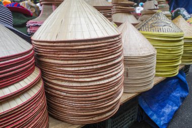 Hoi An, Vietnam - 8 Şubat 2024: Cho Hoi 'de geleneksel Asya konik şapkalarını stokluyor.