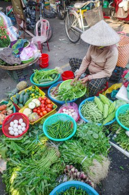 Hoi An, Vietnam - 5 Şubat 2024: Geleneksel Asya konik şapkaları giyen meyve ve sebze satıcıları, Hoi An pazarı, Vietnam
