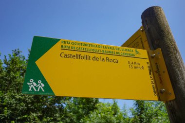 Girona, İspanya - 7 Temmuz 2024: Castellfollit de la Roca, Katalonya 'ya giden yolda yürüyüş yapanlara ve bisikletçilere yol gösteren işaret direği