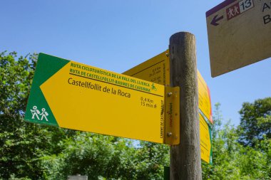 Girona, Spain - 7 July, 2024: Signpost guiding hikers and cyclists on a trail to Castellfollit de la Roca, Catalonia clipart