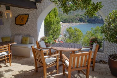 Roses, Spain - 20 July, 2024: Tables on the terrace at El Bulli restaurant, Cala Montjoi, Costa Brava clipart