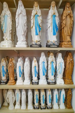 Lourdes, Fransa - 1 Kasım 2024: Bakire Meryem Heykelleri, Mumlar ve diğer Katolik hatıraları Lourdes 'teki bir hediyelik eşya dükkanında satılıyor