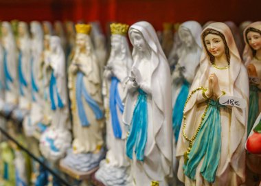 Lourdes, Fransa - 1 Kasım 2024: Bakire Meryem Heykelleri, Mumlar ve diğer Katolik hatıraları Lourdes 'teki bir hediyelik eşya dükkanında satılıyor