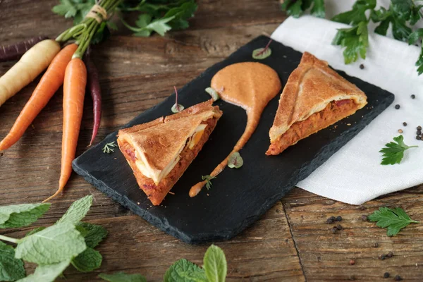 stock image homemade carrot pie on a dark wooden board, top view, copy space 