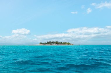 Güneşli bir günde turkuaz suyla çevrili küçük bir ada, Fiji tatil için mükemmel bir yer.