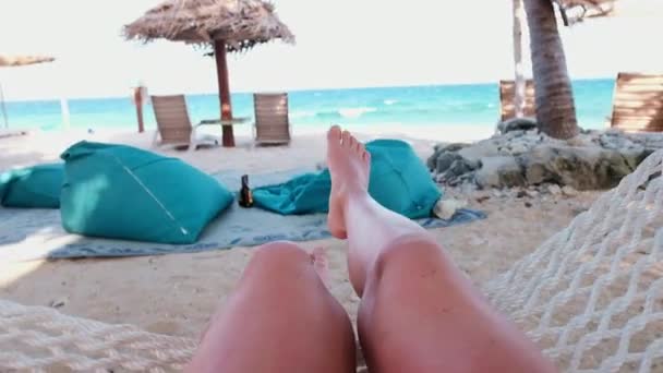 フィジーの美しい砂浜でハンモックでリラックスしてスイングする女の子 彼女の足で見る — ストック動画