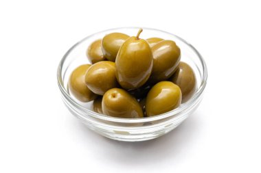 Beyaz arka planda cam bir kasede yeşil zeytinler