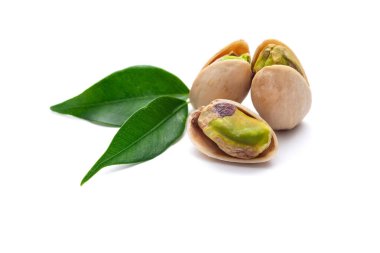 Beyaz arka planda yeşil yapraklı fıstıklar.