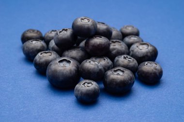 Mavi arka planda bir grup taze yabanmersini.