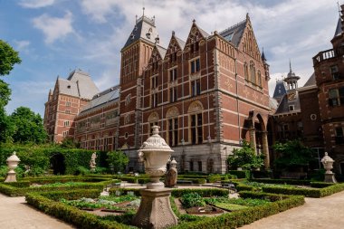 Amsterdam, Hollanda 21 Mayıs 2025: Güneşli bir günde Rijksmuseum binası cephesi ve bahçesi.
