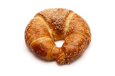 Yuvarlak susam tohumu kruvasanı beyaz arka planda izole edilmiş.