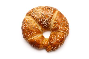 Yuvarlak susam tohumu kruvasanı beyaz arkaplanda izole edilmiş.