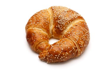 Yuvarlak susam tohumu kruvasanı beyaz arka planda izole edilmiş.