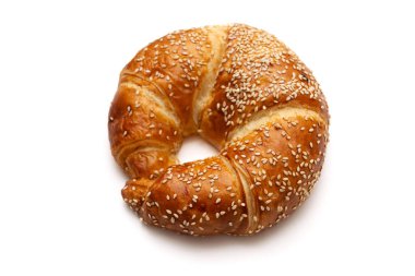 Yuvarlak susam tohumu kruvasanı beyaz arka planda izole edilmiş.