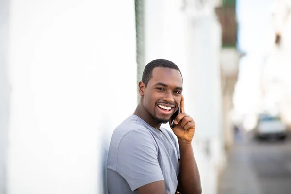 Portrait Happy Young Black Man Talking Mobile Phone Leaning White — Stock Photo, Image