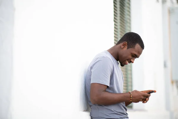 Retrato Lateral Del Guapo Joven Africano Mirando Teléfono Móvil Mientras — Foto de Stock