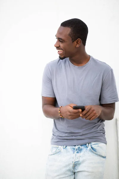 Portrét Pohledného Mladého Černocha Držícího Mobilní Telefon Odvrací Pohled Usmívá — Stock fotografie