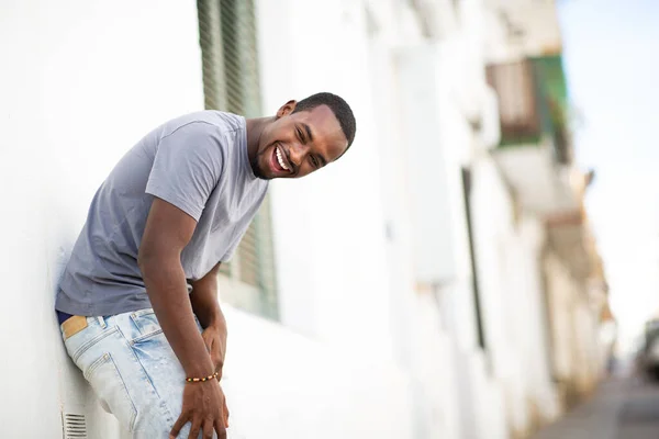 Portret Van Vrolijke Jonge Afrikaanse Man Leunend Tegen Muur Buiten — Stockfoto