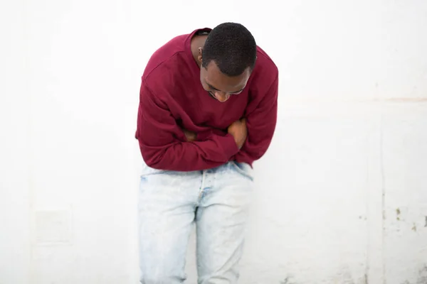 Портрет Молодого Африканца Смотрящего Вниз Улыбающегося Руками Скрещенными Белой Стене — стоковое фото